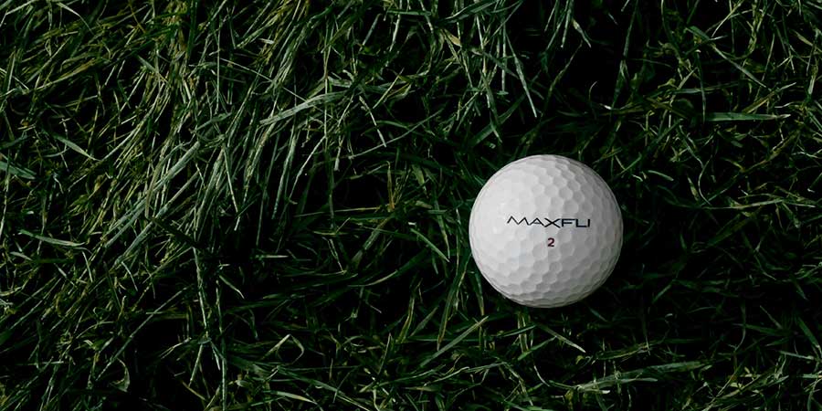 ein Golfball liegt im Gras