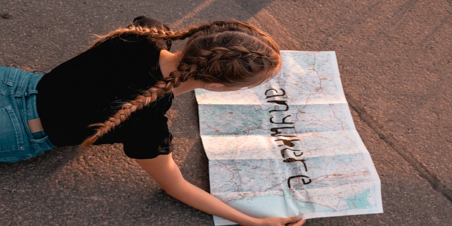 Eine Frau schaut sich eine Weltkarte bei ihrer Reise mit ISIC nach Amerika an