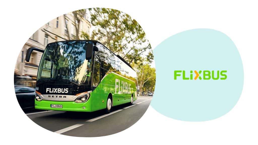 Ein Bus des ISIC Partners FlixBus fährt auf einer Straße. Im Hintergrund stehen Bäume.