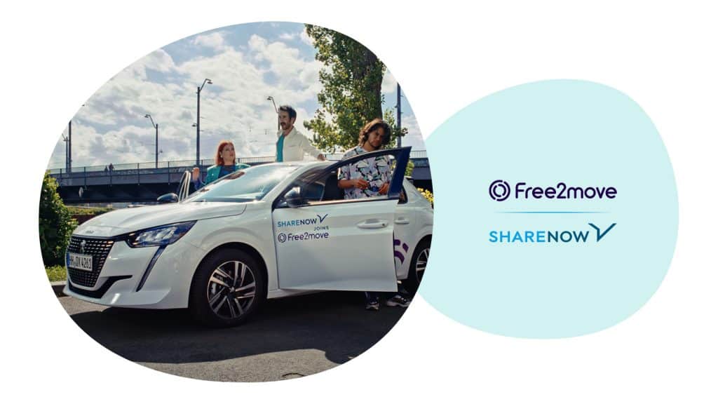 Drei junge Leute stehen neben einem Share Now Auto.
